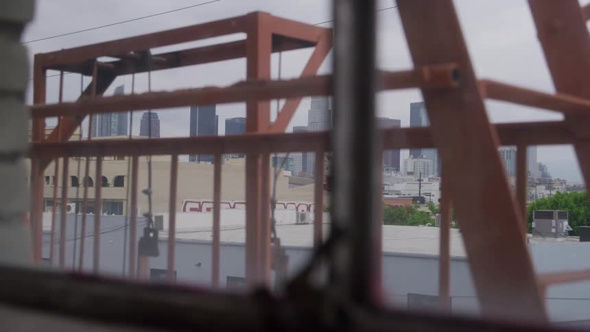 A pulley system is on a rooftop of a building in a city