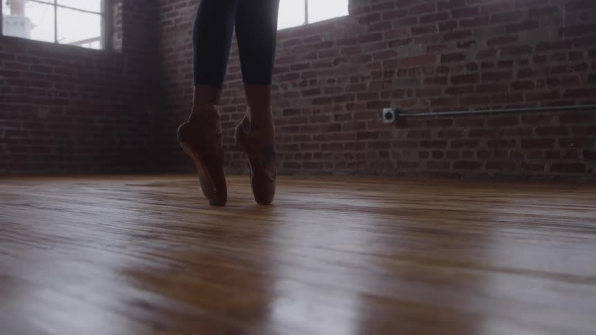 Close up of a female ballet dancer dancing on her tip toes in a room during daytime
