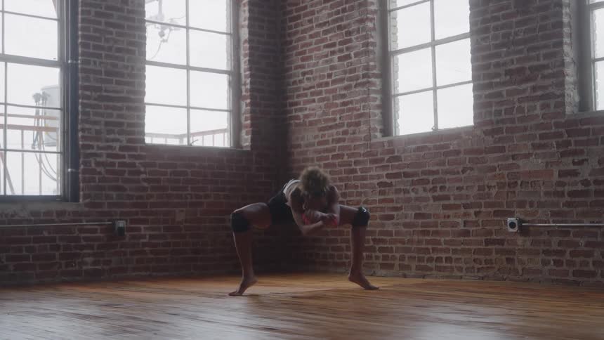 A young ballet dancer performing while kneeling on the floor