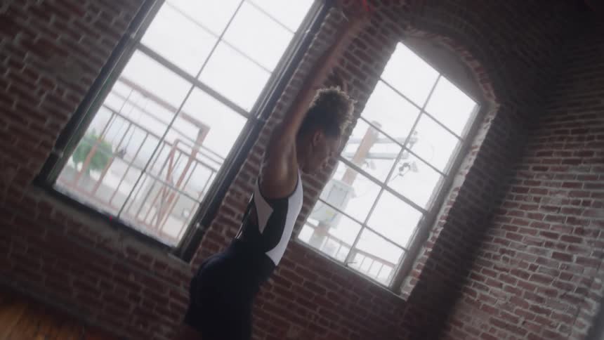 A black female dancing in a well lit studio