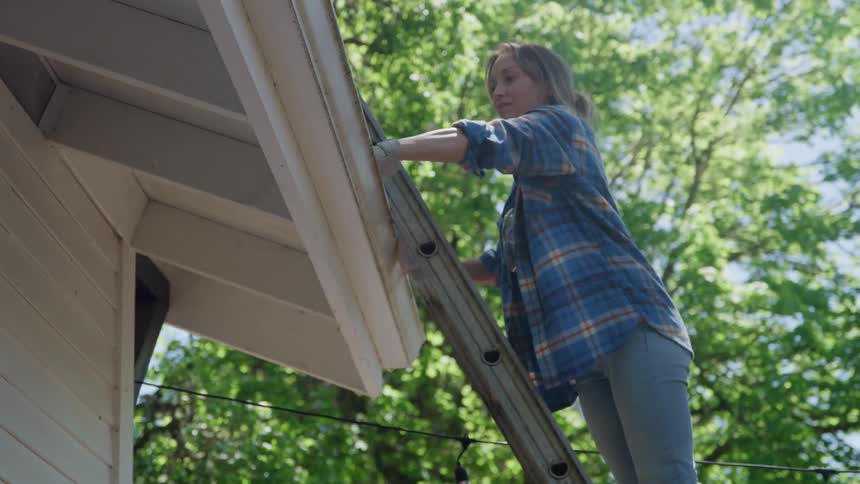 The woman cleans her gutters