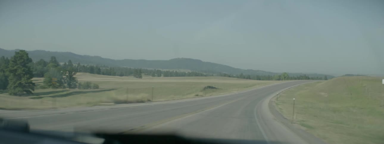 A car is traveling down a long small road