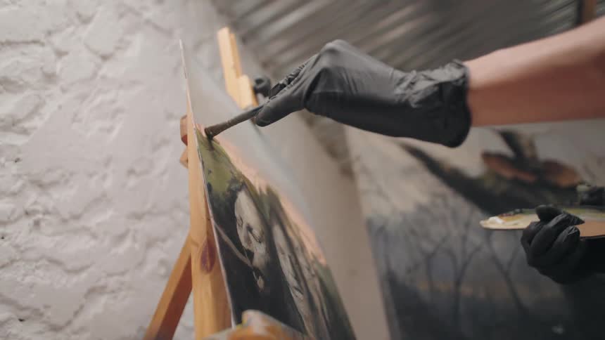 The person is painting on the canvas