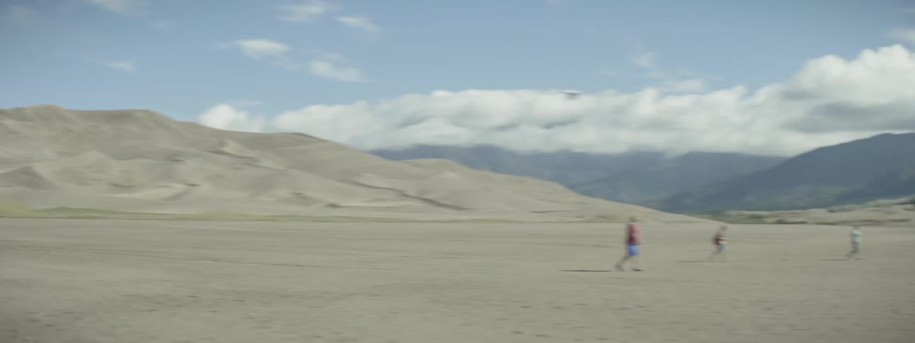 Three people walking in a dry lake bed