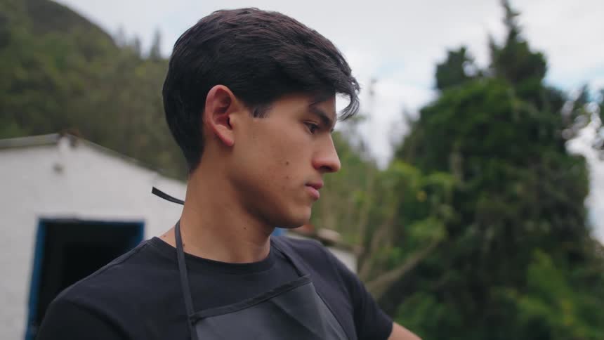 Young artist attentively observes his work outdoors