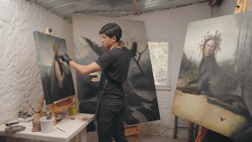 Artist paints a portrait in a studio surrounded by surrealist works