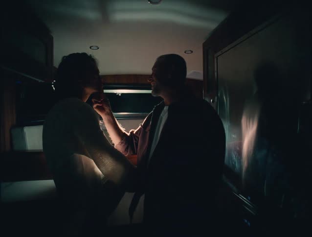 Man and woman traveling in a rv smile while teasing each other