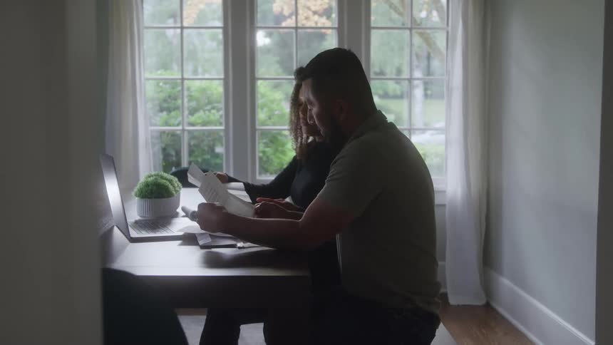 A woman and a man holding documents with the woman saying something to the man