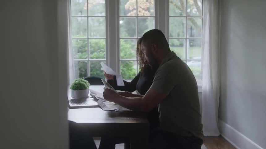 Man and woman review documents together at a table in a naturally lit room