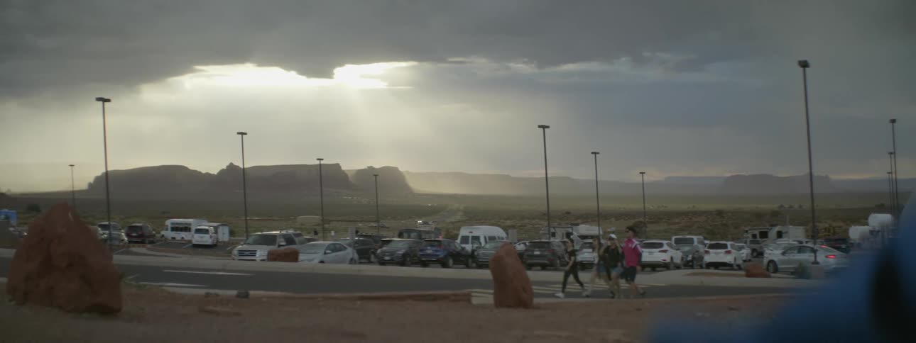 Group of teenagers walking past a parking lot