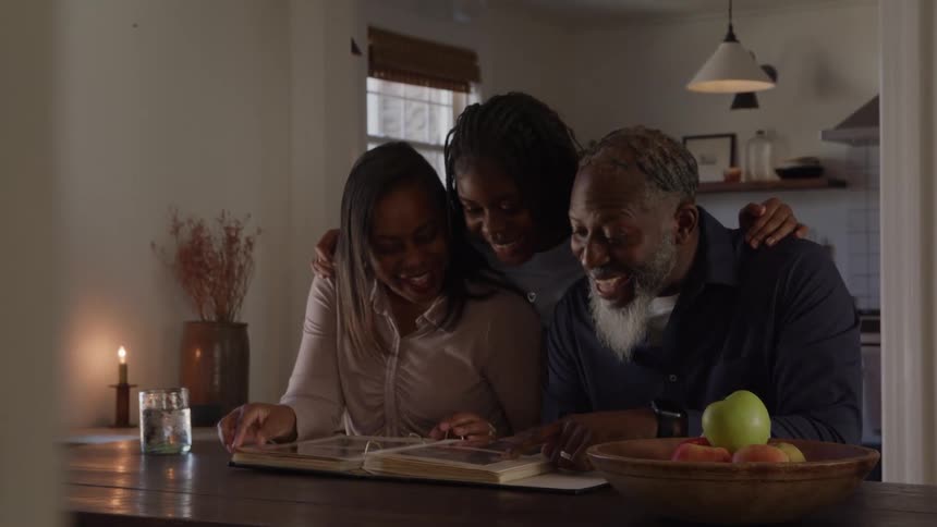 A woman looks through a photo album with her mother and father