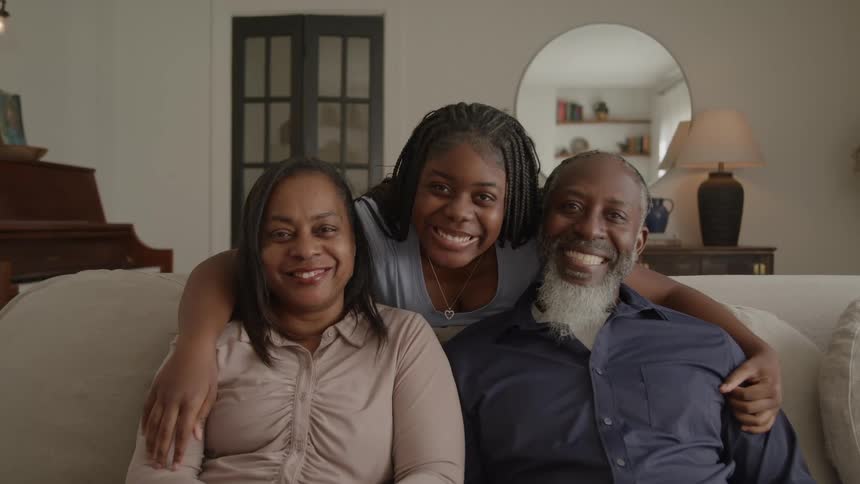 Family smiling together on the living room couch