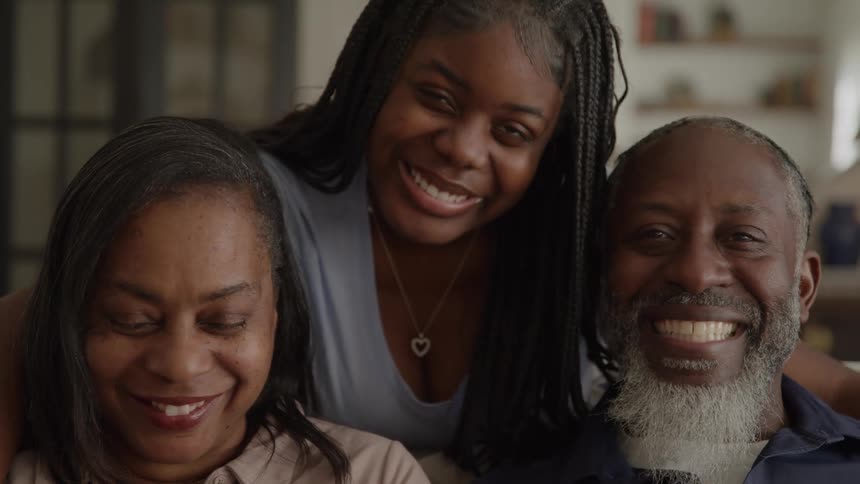 A happy family smiles together in their cozy living room
