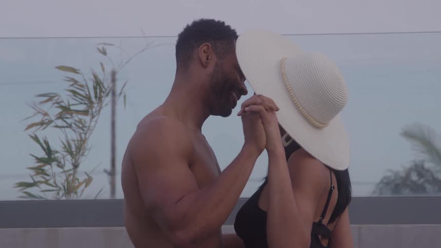 A couple dances closely smiling at each other outdoors under open sky