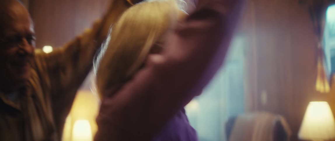 Woman smiling as her husband spins her while dancing