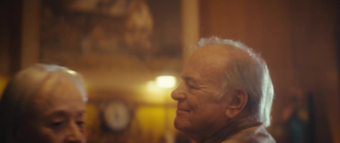 Elderly couple dancing together in a warm softly lit room