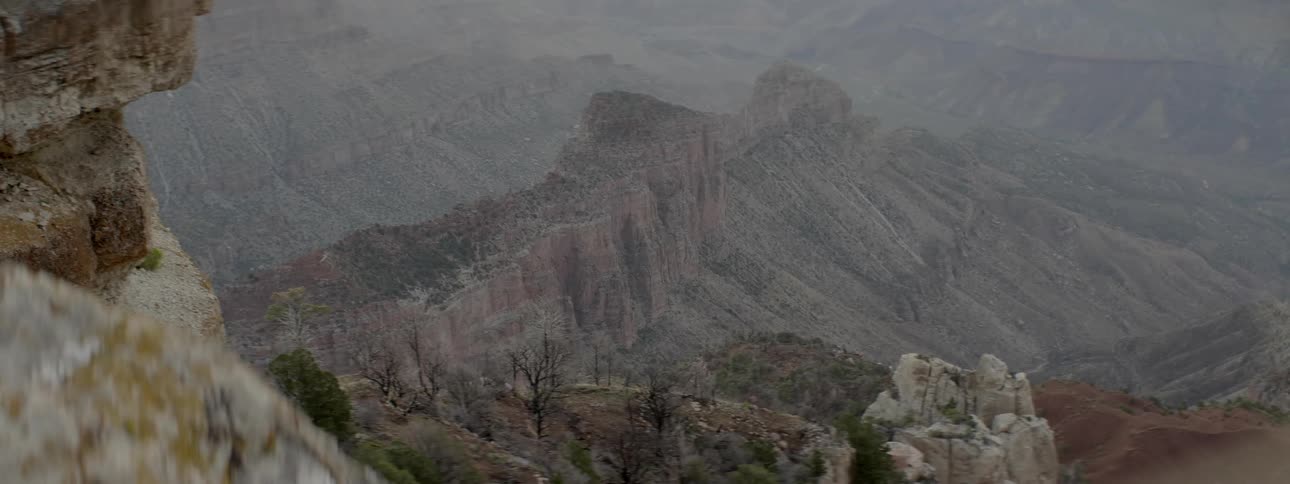 The mountain range has light fog all around