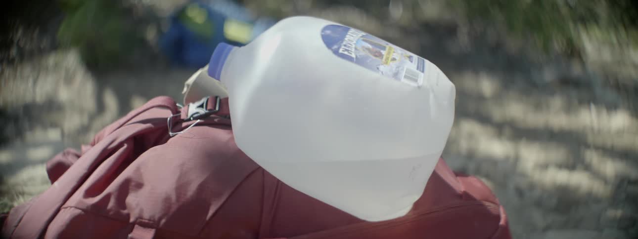 A water bottle is attached to a backpack