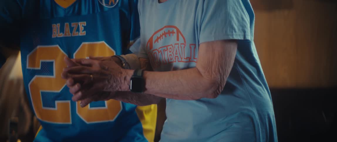 Elderly people celebrate together indoors wearing sportsthemed shirts