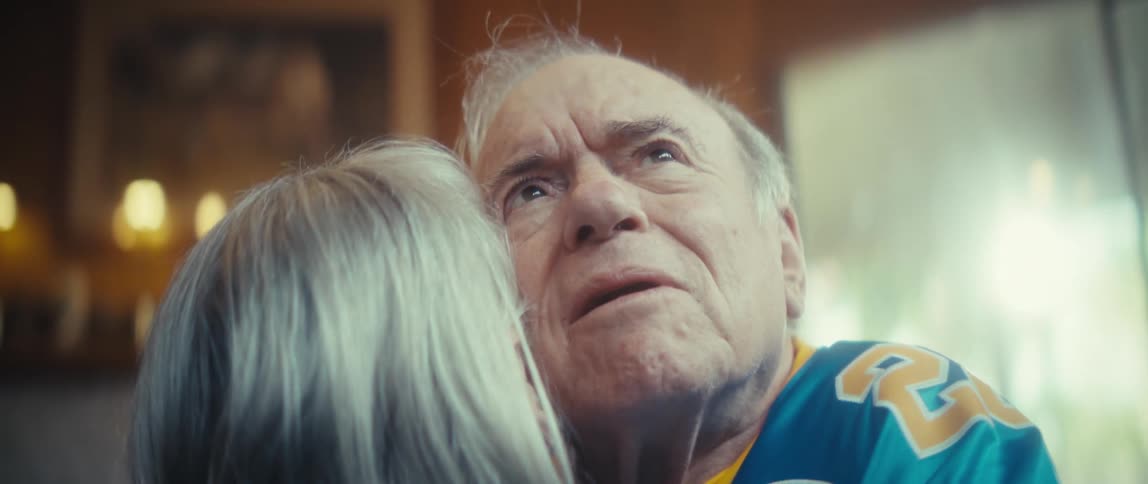 Elderly man smiling emotionally while hugging a woman