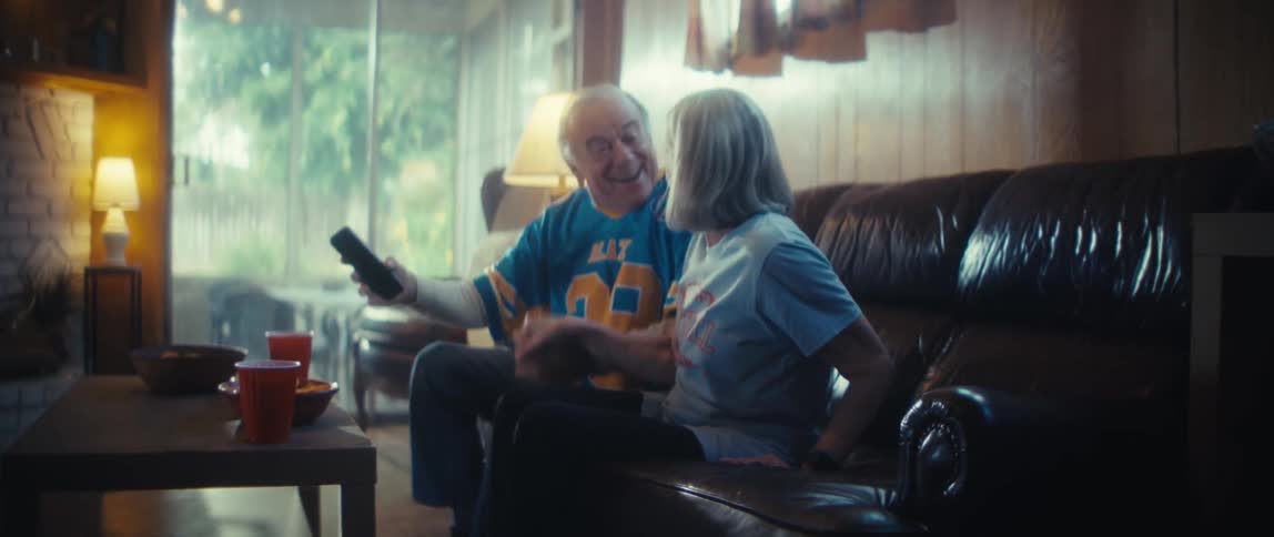 Elderly couple smiling and spreading their arms in celebration