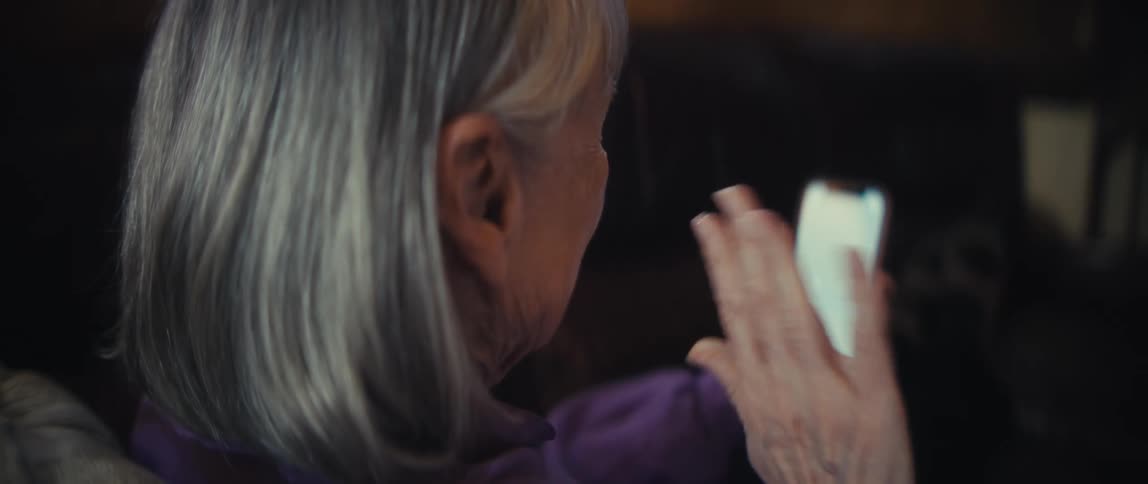 Elderly woman waving during a video call on her smartphone