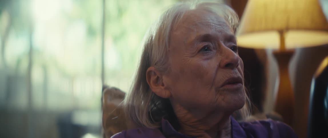 An elderly woman holding a cellphone and looking up distracted