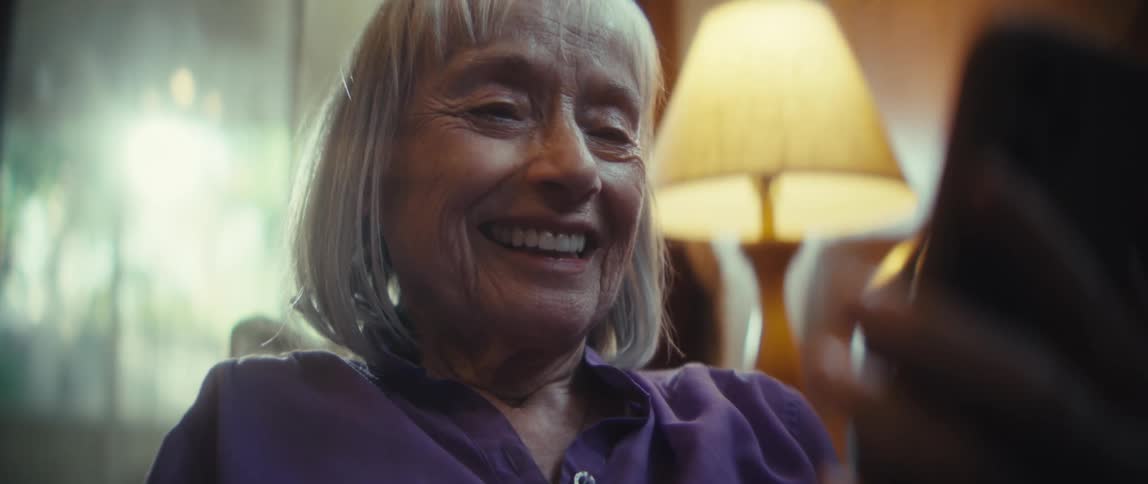 A woman smiles at her camera