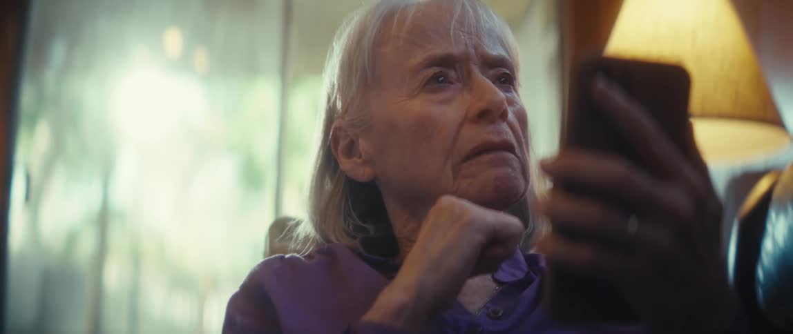 A woman thinks while holding her phone