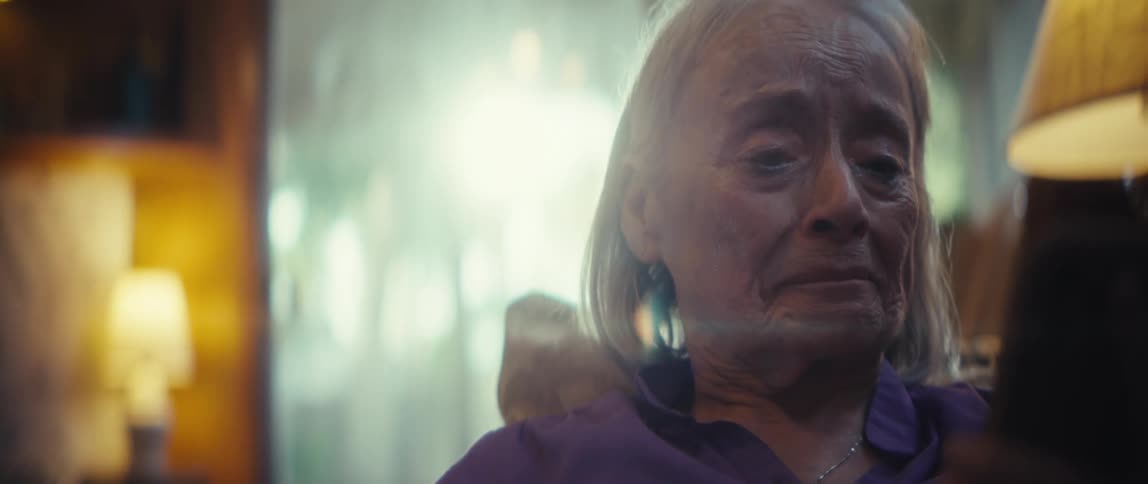 Elderly woman with an emotional expression holding her smartphone