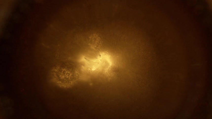 Light shines through a brown liquid