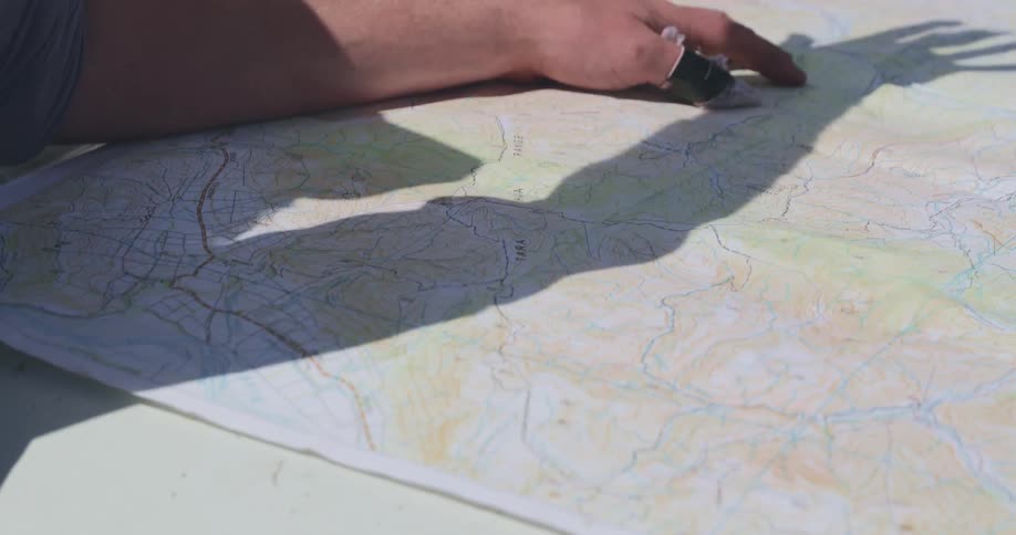 Hands examining a topographic map on a table