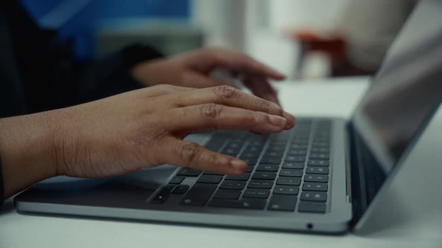 A person types on a laptop