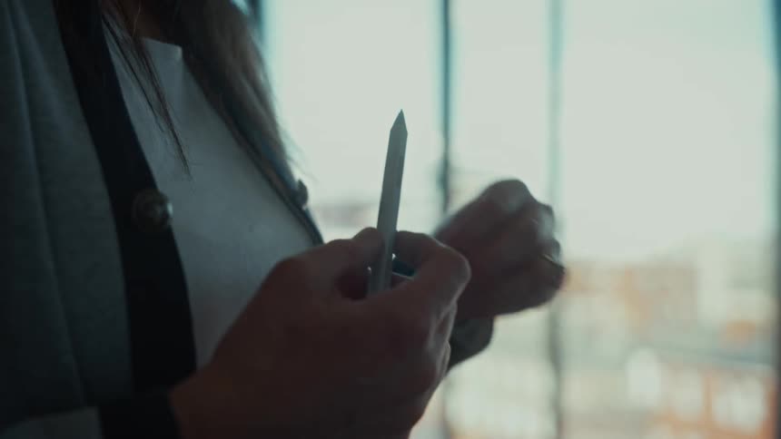 A woman holding a pen is moving her other hand