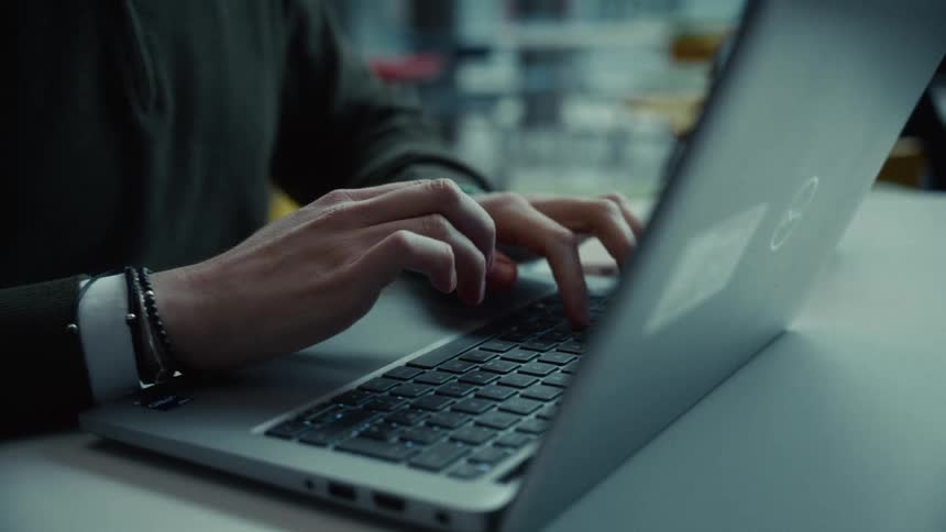 The man is typing on his laptop