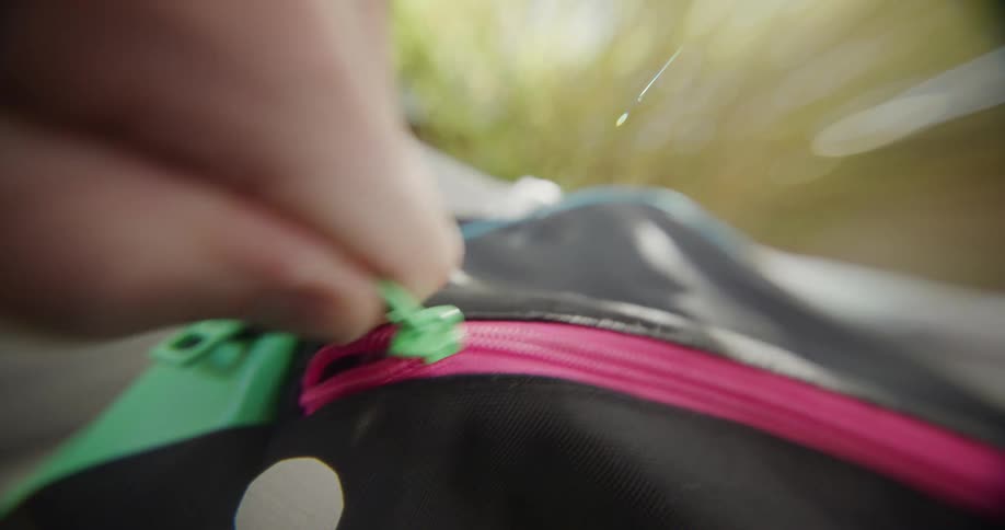 The person zips the bag shut
