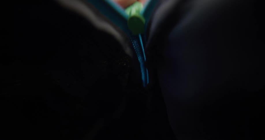 Hand closing the blue zipper of a backpack