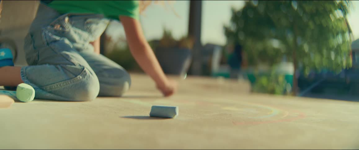A girl playing and drawing on the ground with chalk