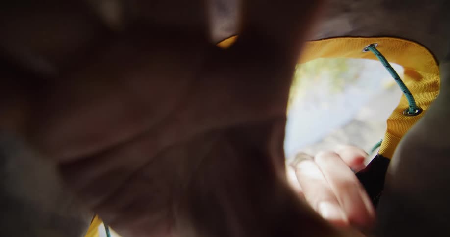 A man is reaching his hands into a bag