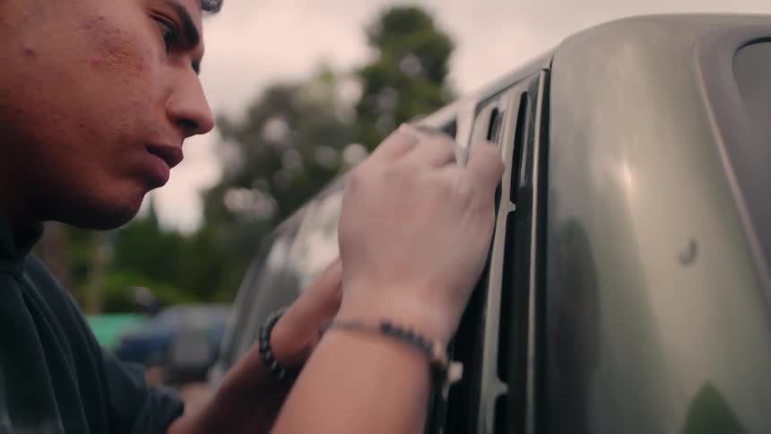 The man carefully sands the vehicle