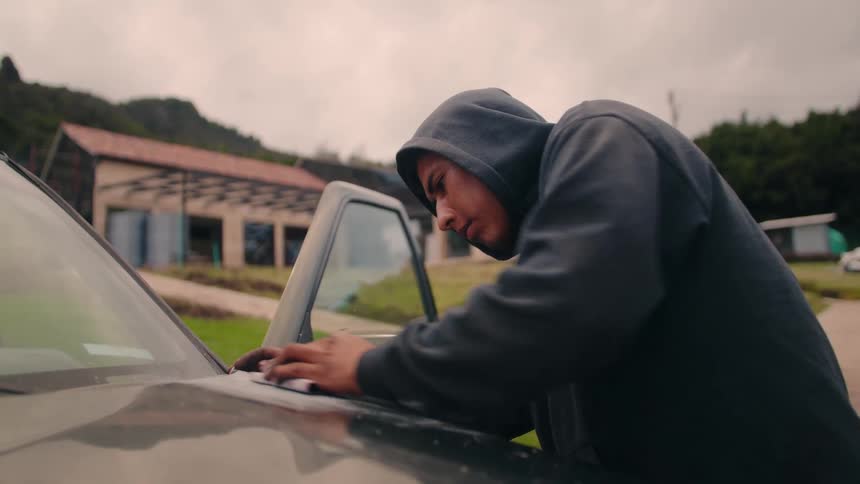 The man sands the car on a cloudy day