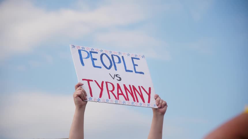 A protestor is holding a sign high in the air