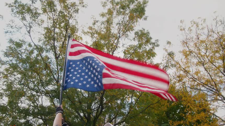 The wind blows the upside down flag being waved