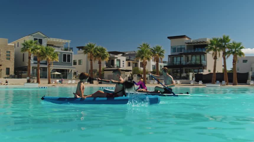 The family race in kayaks in the swimming pool