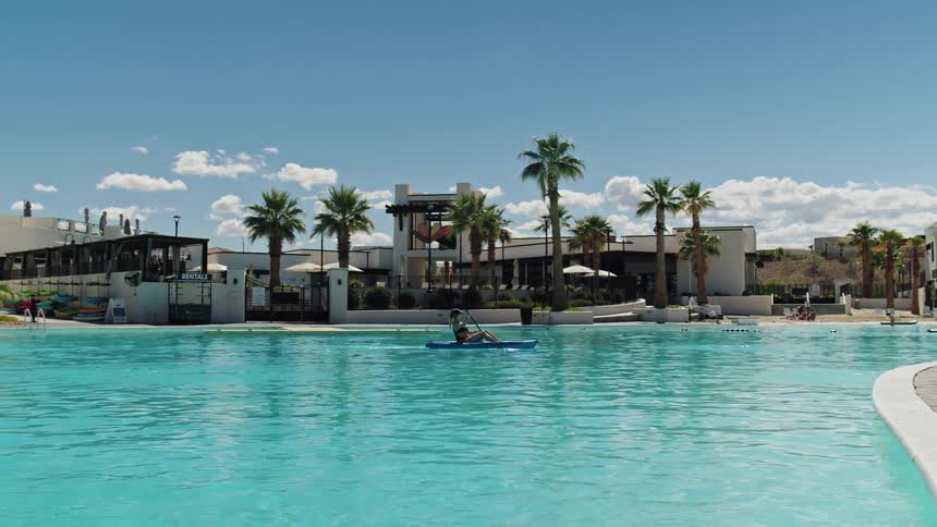 The woman paddles on a kayak in the pool