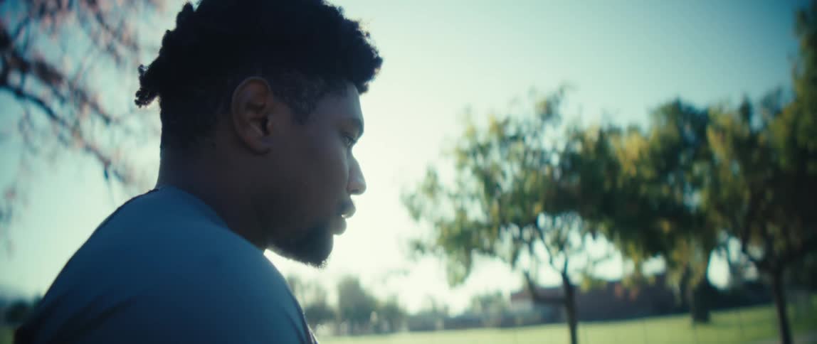 A man is doing warm up exercises with a football