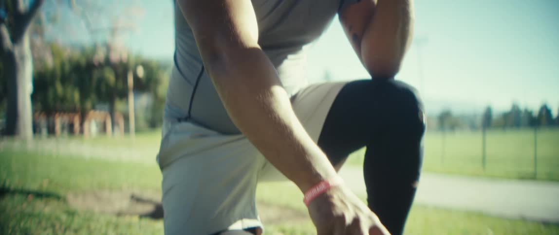 The man kneels with his football