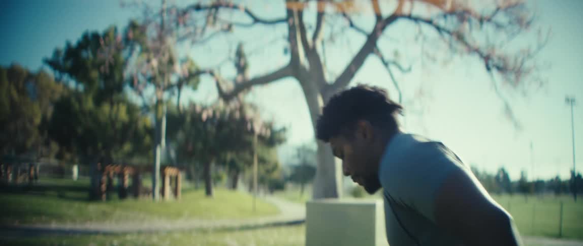 Football player trains on his footwork in the park on a sunny autumn day