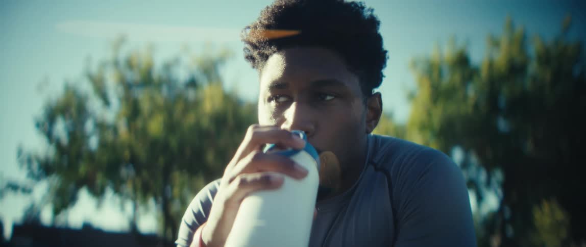 A man walks over to his water bottle and takes a drink