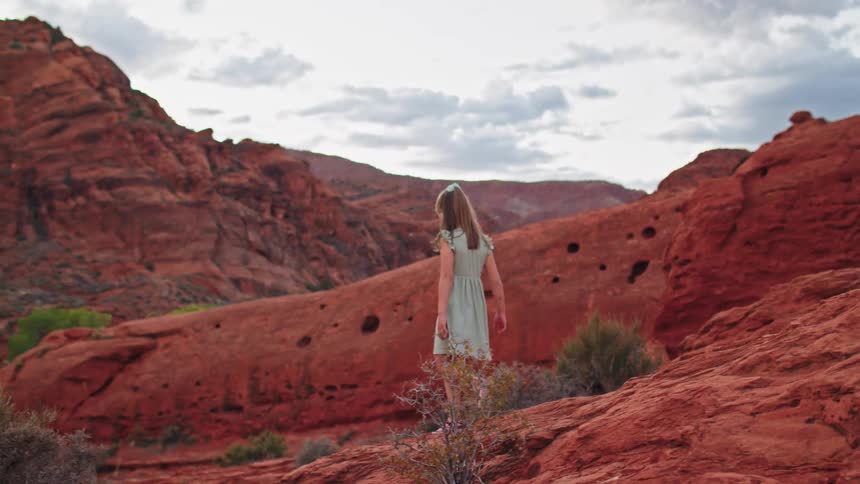 The child gets up and walks through the canyon